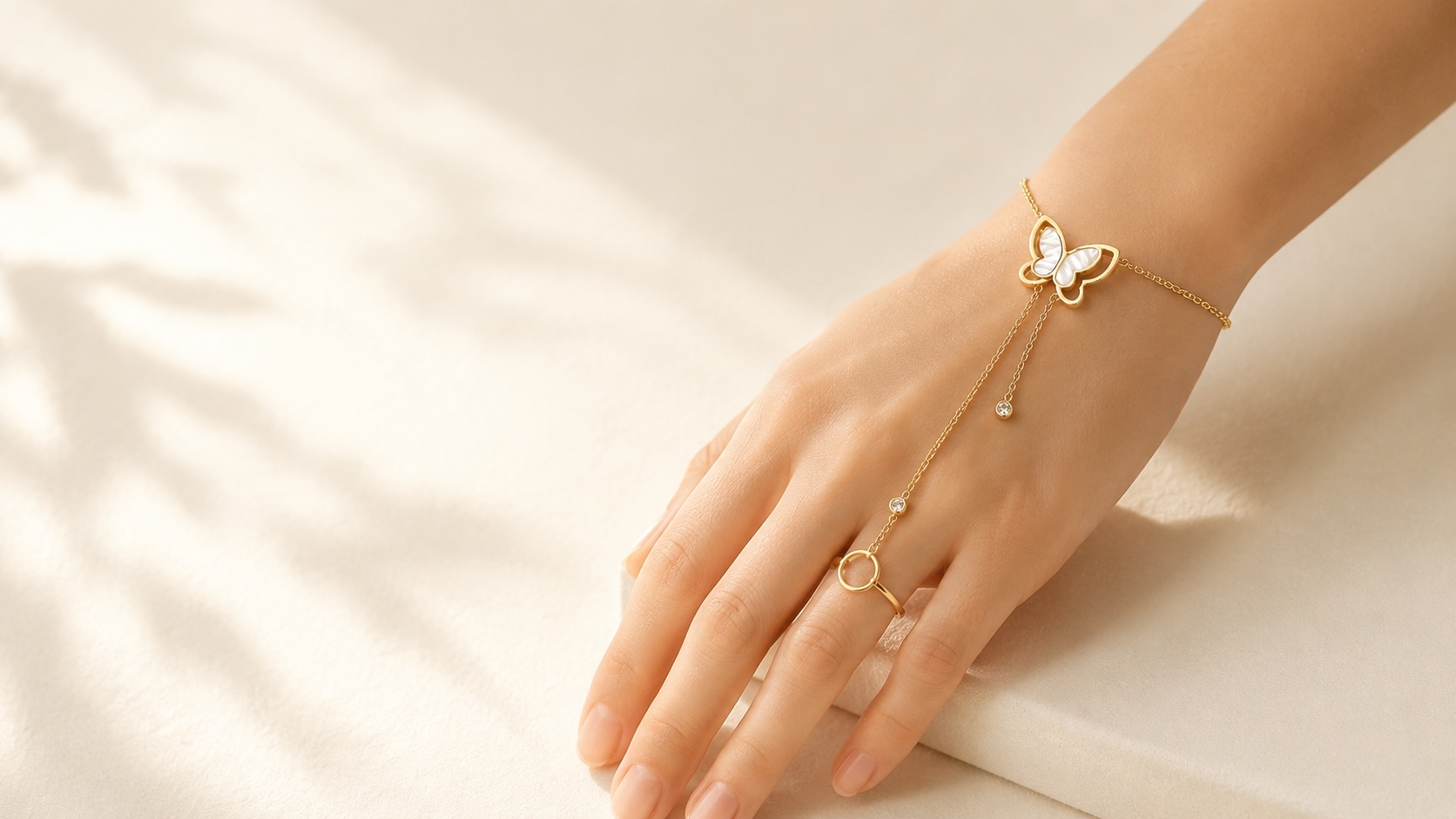 The Editorial hand chain with butterfly detail worn near the wrist.